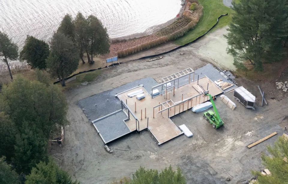 Bâtoment en construction sur dalle de béton en bordure d'un lac